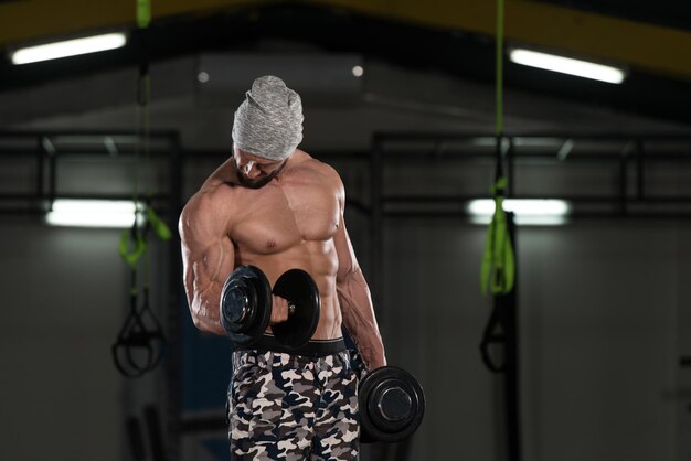 Ejercicio de bíceps con mancuernas en un gimnasio