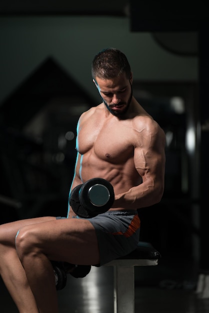 Ejercicio de bíceps con mancuernas en un gimnasio