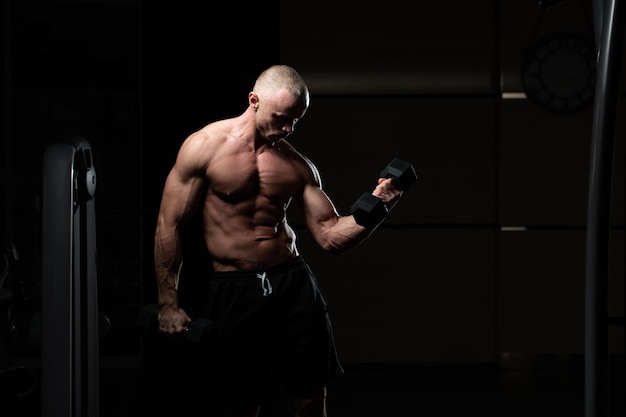 Ejercicio de bíceps con mancuernas en un gimnasio