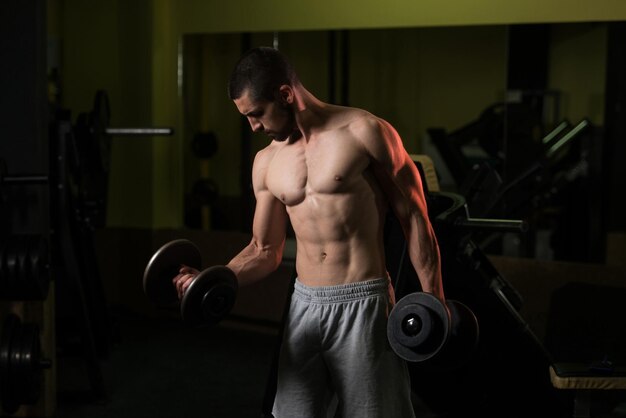 Ejercicio de bíceps con mancuernas en un gimnasio