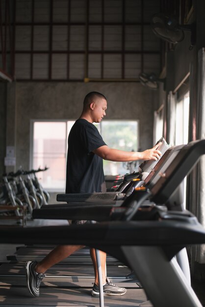 Ejercicio de deporte hombre usando caminar en la cinta en el gimnasio