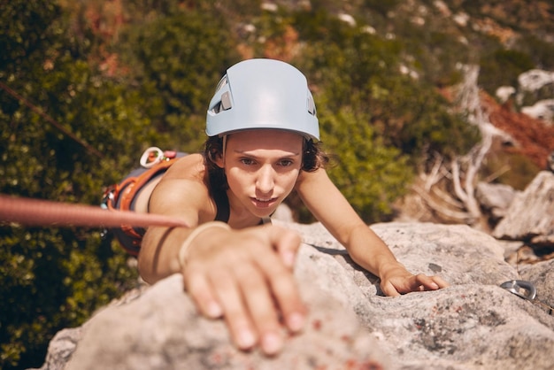 Ejercicio deportivo y montañismo con una mujer escaladora escalando o haciendo rappel en un acantilado Entrenamiento físico y entrenamiento con una mujer joven en una escalada en el bosque o bosques en la naturaleza desde arriba
