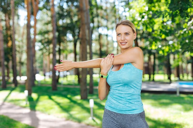 Ejercicio deportivo. Mujer positiva alegre moviendo su cuerpo mientras hace ejercicio deportivo