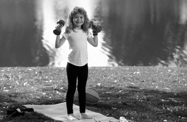 Ejercicio deportivo para niños niños deportivos estilo de vida saludable niño niño levantando pesas fuera del deporte