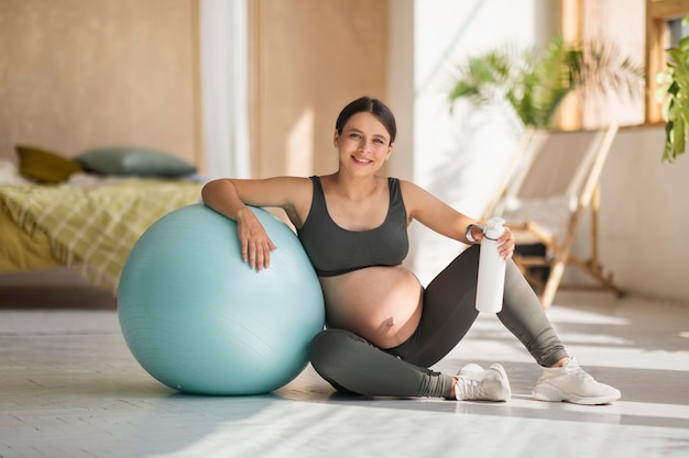 Ejercicio y embarazo hermosa mujer embarazada en ropa deportiva sentada  cerca de big fitball