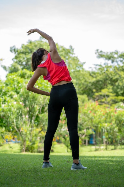 Ejercicio de entrenamiento femenino Healty Young antes de correr o una sesión de entrenamiento físico en City Park