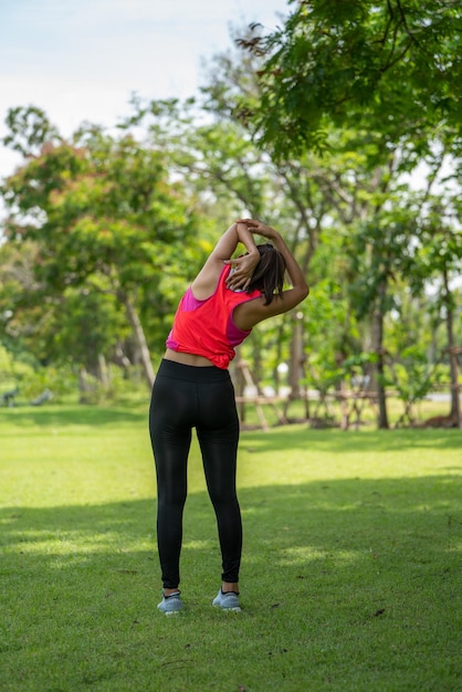 Ejercicio de entrenamiento femenino Healty Young antes de correr o una sesión de entrenamiento físico en City Park