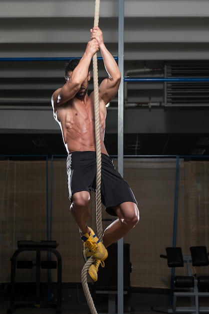 Ejercicio de escalada de cuerda de fitness en entrenamiento de gimnasio de fitness