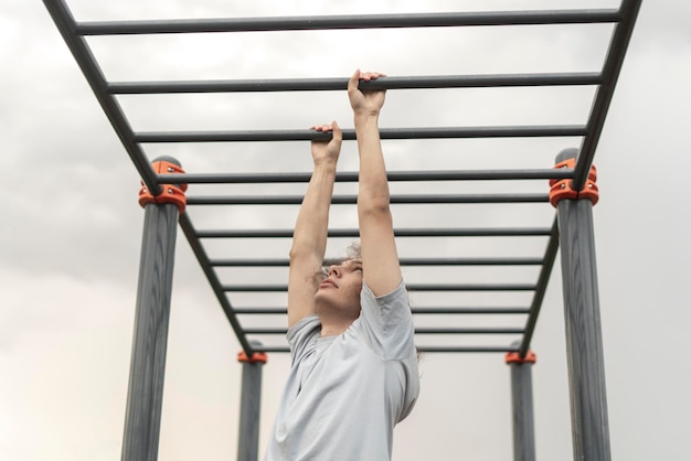 Ejercicio físico en barras de mono al aire libre, entrenamiento de los músculos del brazo, escalada en escalera