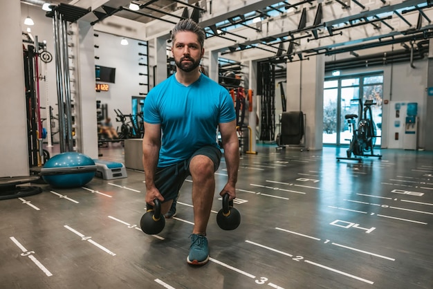 Ejercicio. Joven barbudo haciendo ejercicio en el gimnasio