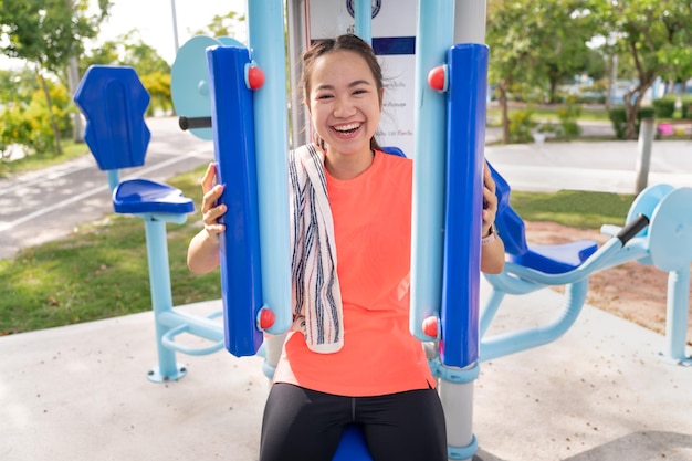 Ejercicio de mujer adolescente en prensa de pecho en el área de deportes, gimnasio al aire libre en el parque