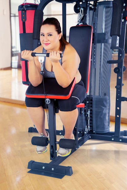 Ejercicio de mujer gorda con máquina de fitness