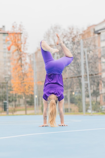 Ejercicio de parada de manos de fitness deportivo para el equilibrio de calistenia entrenamiento de mujer adulta media hispana