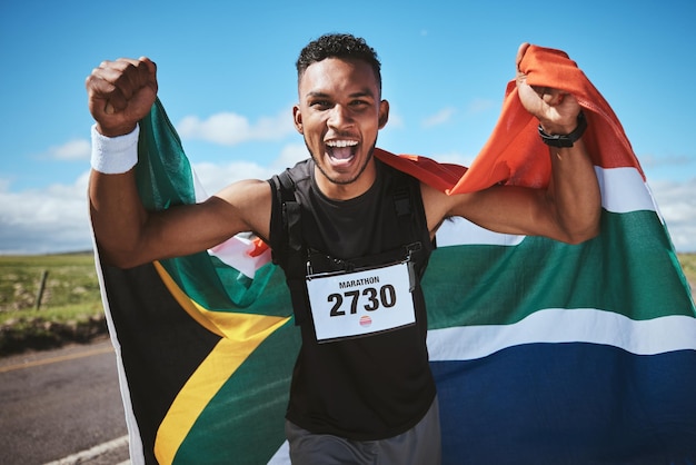 Ejercicio de retrato y bandera de Sudáfrica con un corredor en una calle en la naturaleza para motivación o éxito Ganador de fitness y salud con un atleta animando durante el entrenamiento cardiovascular o de resistencia