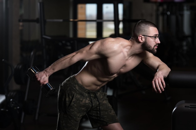 Ejercicio de tríceps con mancuernas en un gimnasio