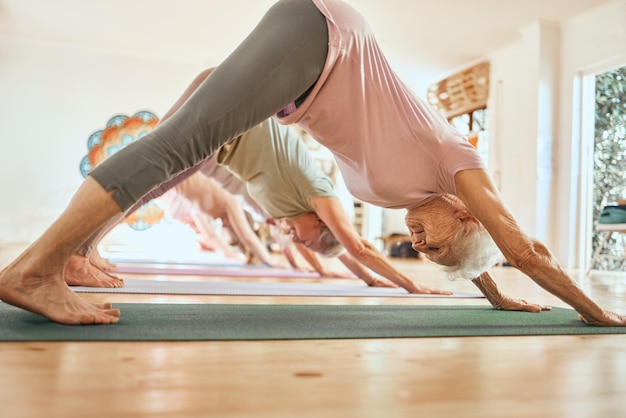 Foto ejercicio de yoga y anciana en clase de estudio y lección para el cuidado del cuerpo y el bienestar físico equilibrio deportivo y anciana haciendo pose de perro hacia abajo para entrenar pilates y hacer ejercicio en el gimnasio