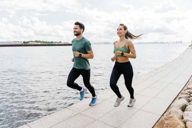 Ejercicios en equipo de una pareja joven Los atletas son amigos de los ejercicios de carrera La gente en ropa deportiva