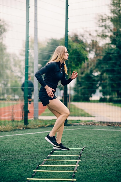 Ejercicios de escalera de velocidad de entrenamiento de mujer