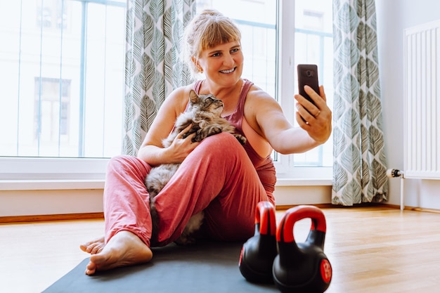 Ejercicios relajantes de yoga con mascotas para mujeres adultas con sobrepeso y pechos grandes. vacaciones con gato