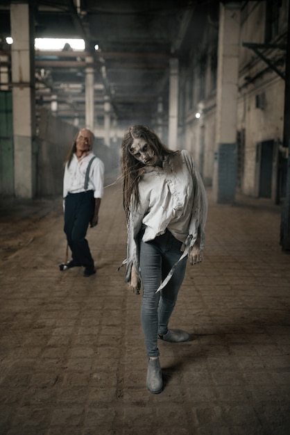 Ejército de zombies en busca de carne fresca, muertos vivientes en una fábrica abandonada, lugar aterrador. Horror en la ciudad, ataque de bichos espeluznantes, apocalipsis del fin del mundo, monstruos malvados sangrientos