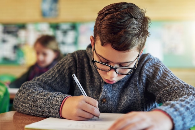 Él va a sobresalir en esta prueba Foto de un estudiante de primaria trabajando en clase