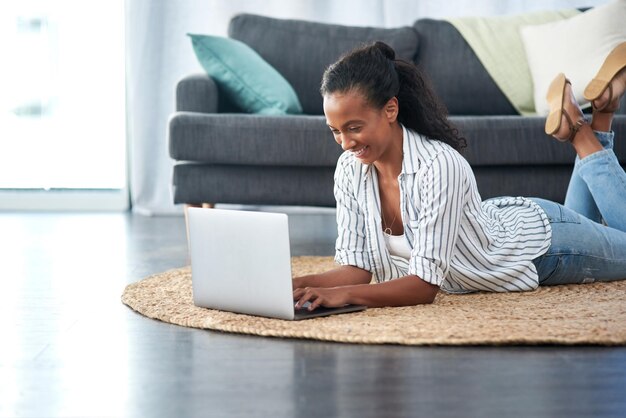 Ela está indo bem no jogo de blog Foto de uma jovem usando um laptop em casa