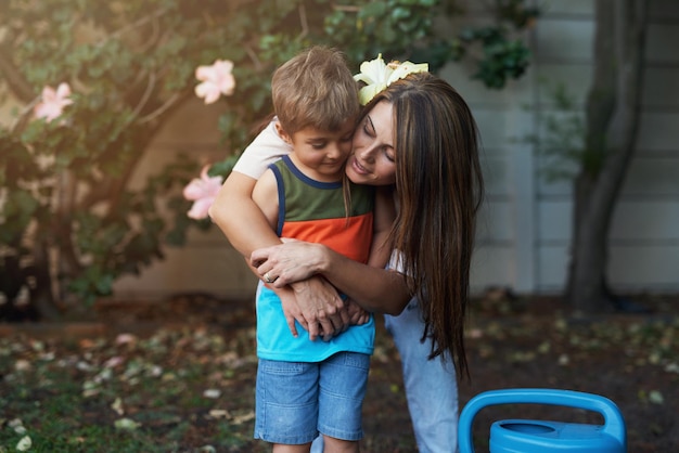 Ela o ama em pedaços Foto de uma mãe abraçando seu filho no jardim