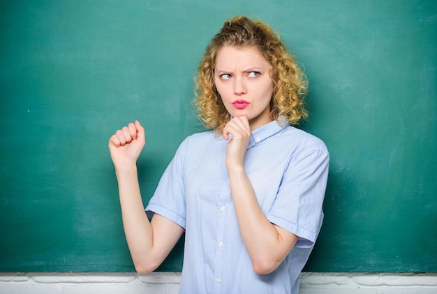 Ela pondera sobre a resposta mulher professora na escola lição educação Estudantes vida de volta à escola mulher gosta de estudar dia do conhecimento lousa vazia estudante de informações no quadro-negro