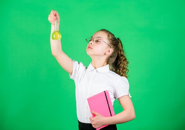 Ela precisa de um conselho de especialista pequena garota inteligente com frasco de teste de volta à escola pesquisa científica em laboratório Educação e conhecimento para crianças pequenas estudam lição de biologia com nota