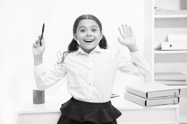 Ela sabe a resposta certa Menina criança usa uniforme escolar em pé expressão de rosto animado A criança esperta de colegial parece animada fundo branco interior Garota lembre-se da resposta certa Pronto para responder