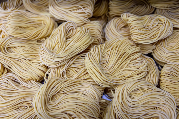 Elaboración artesanal de fideos en un restaurante italiano Fideos amarillos en proceso de secado