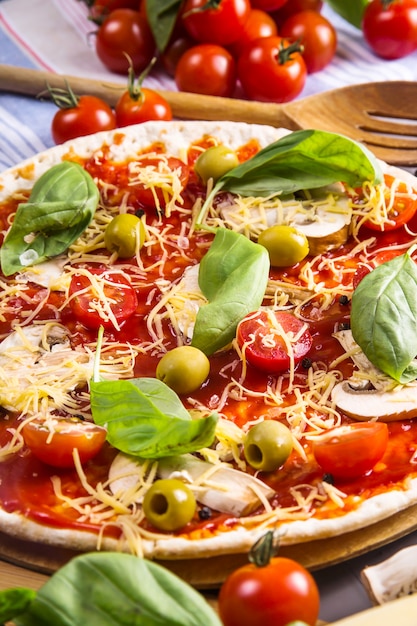 Elaboración de pizzas caseras con masa, champiñones, tomates y queso.