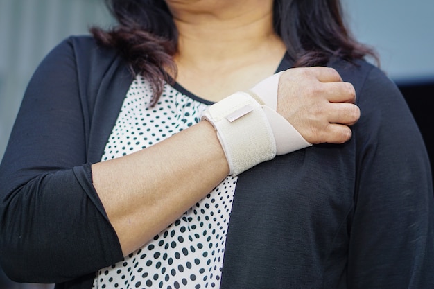 Elastischer Verband asiatischen Damengebrauches an ihrer Hand im Büro.