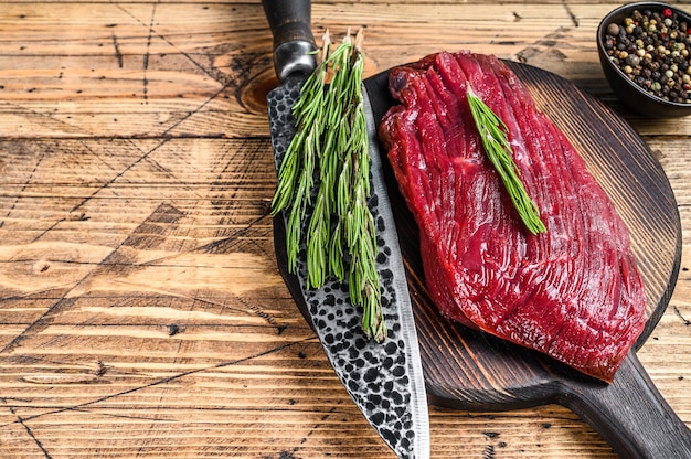 Elch rohes Steak aus wildem Fleisch auf einem Schneidebrett. Holztisch. Draufsicht.