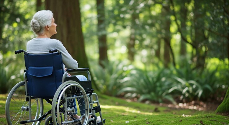 Elderly woman in a wheelchair enjoying nature in a forest