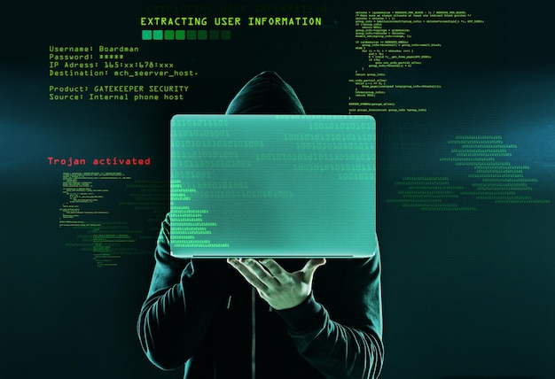 Ele acabou de encontrar sua próxima vítima Foto de um hacker não identificável segurando um laptop contra um fundo escuro