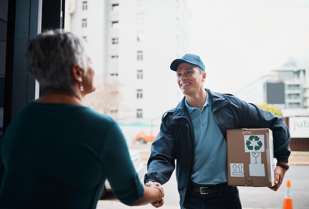 Ele adora conhecer novos clientes Foto recortada de um jovem bonito entregando um pacote para um cliente