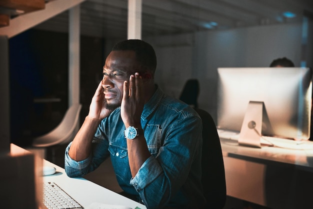 Ele atingiu um bloqueio criativo Foto de alto ângulo de um jovem designer masculino parecendo estressado enquanto trabalhava em seu computador no escritório