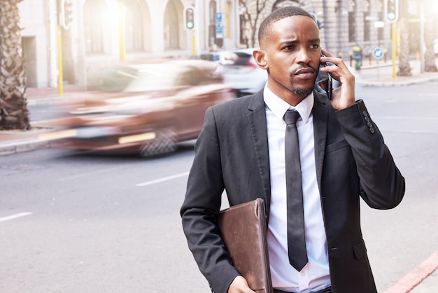 Ele dá os tiros. Retrato recortado de um jovem empresário bonito fazendo um telefonema durante seu trajeto matinal para o trabalho.