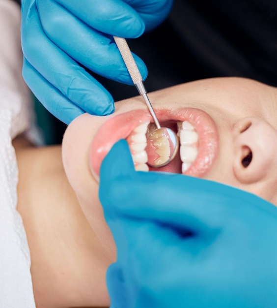 Ele é um dentista completo. foto de uma mulher tendo seus dentes verificados no consultório do dentista.