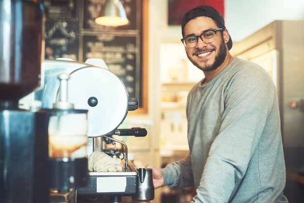 Ele é um mestre quando se trata de café Retrato de um jovem barista trabalhando em um café