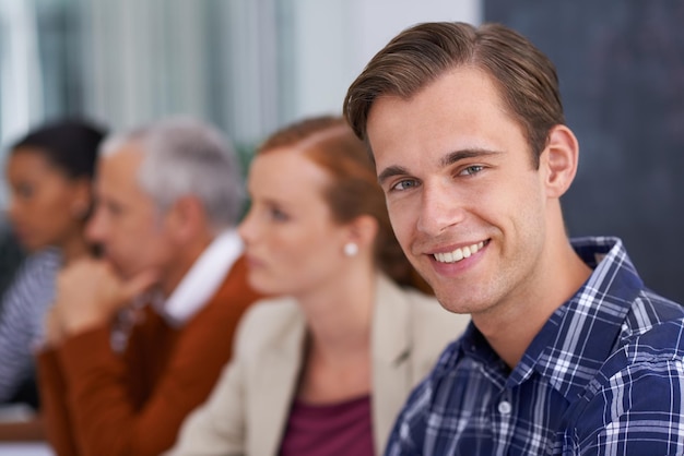 Ele encontrou seu lugar dentro da empresa Um jovem empresário sorrindo em uma reunião de trabalho