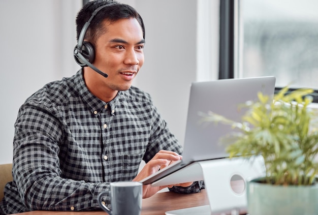 Ele está em uma solução Foto recortada de um jovem e bonito agente de call center trabalhando em seu laptop