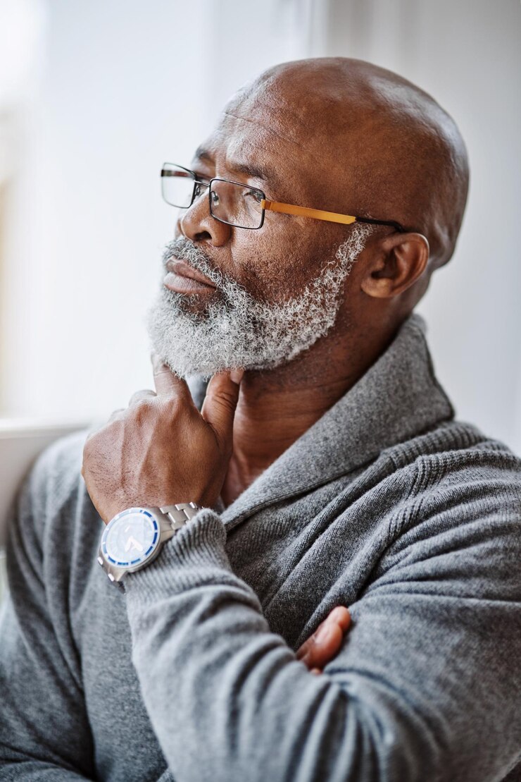 Foto ele passa muito tempo pensando em um belo homem sênior olhando pensativo enquanto relaxa em casa