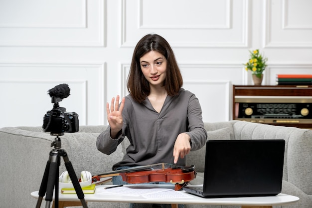 Elearning dando clases de violín de forma remota en casa joven linda hermosa niña explicando