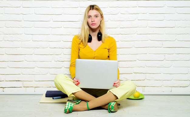Elearning ernsthafte weibliche Studentin sitzt auf dem Boden mit gekreuzten Beinen studiert online zu Hause hoch