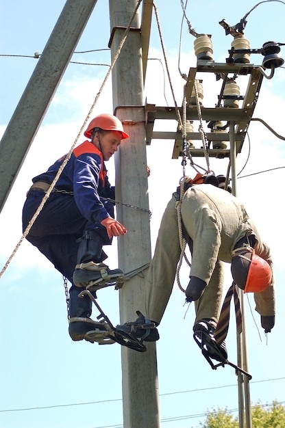 Un electricista ayuda al trabajador afectado por una descarga eléctrica. Entrenamiento en un maniquí.