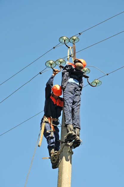 Un electricista ayuda al trabajador afectado por una descarga eléctrica. Entrenamiento en un maniquí.