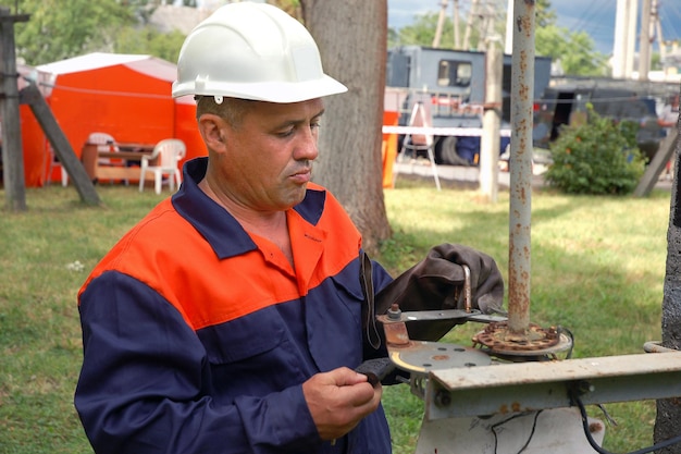 Un electricista desconecta una línea eléctrica usando un seccionador lineal de alto voltaje.