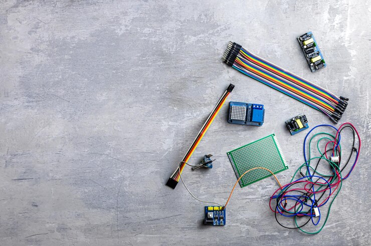 Foto electricista, electronica. diferentes cables y detalles eléctricos sobre un fondo de madera gris. lugar para texto